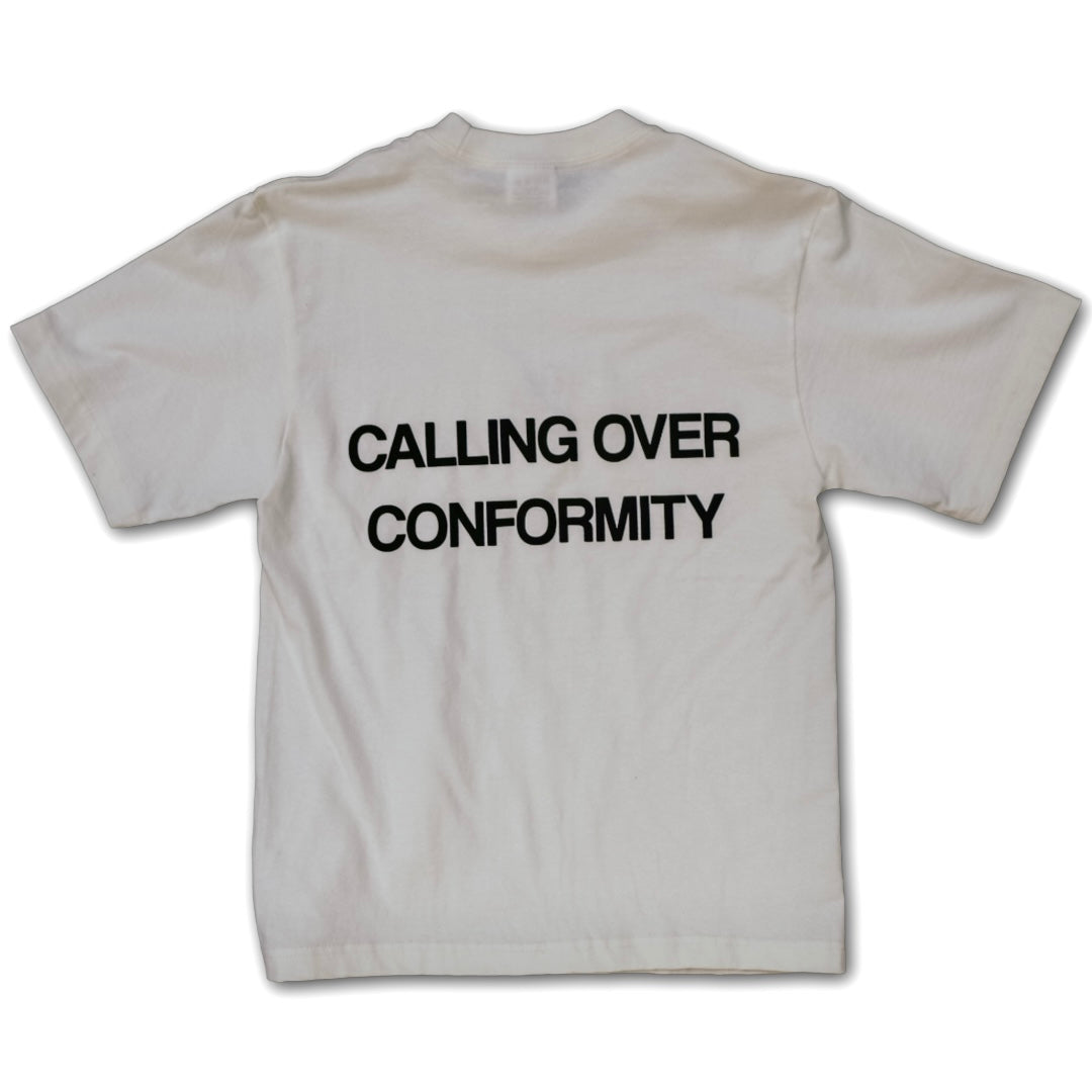 White t-shirt with black text 'Calling Over Conformity' on a white background